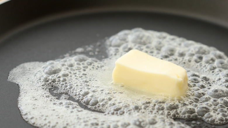 Butter melting in a black skillet