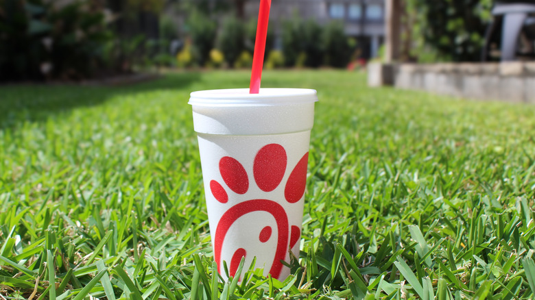 Chick-fil-A drink sitting in the grass on a sunny day