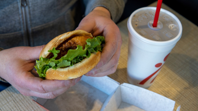 Hands holding a Chick-fil-A sandwich