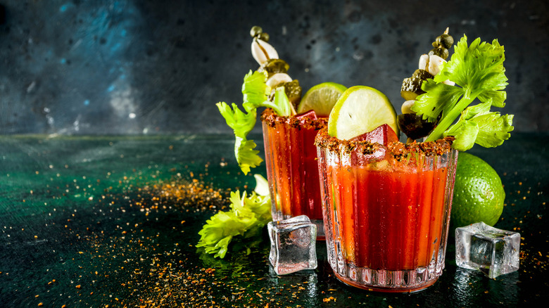 Two bloody marys garnished with lime, celery, and skewers