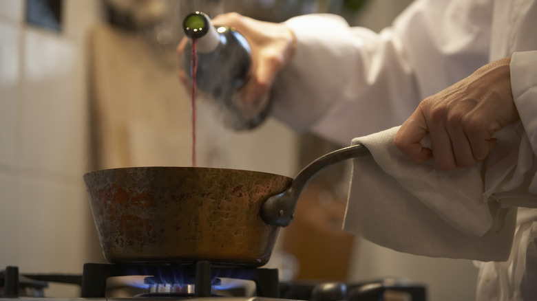 person cooking with red wine