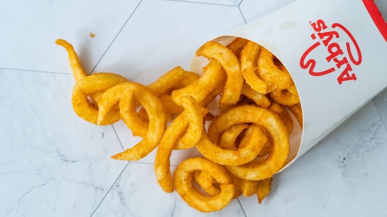 A box of Arby's curly fries on a white table.