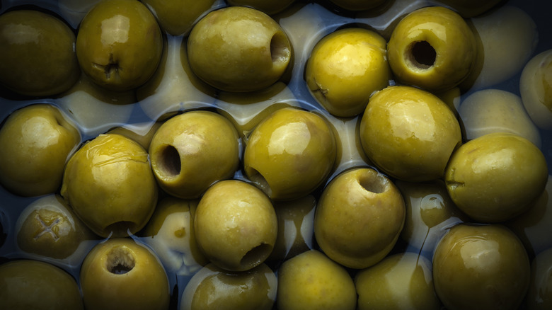 Pitless green olives sitting in a clear brine