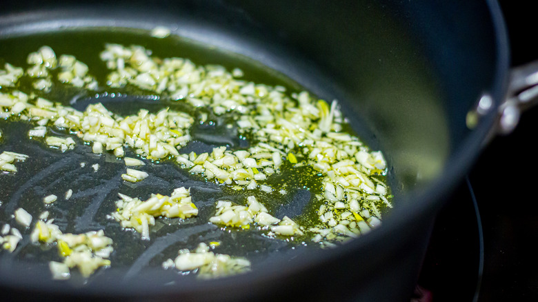 minced garlic cooking in olive oil in a nonstick pan