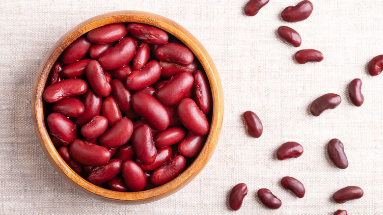 Kidney beans in a white bowl with scattered beans next to it