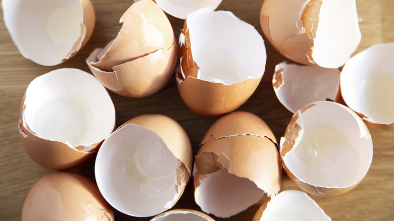 A collection of broken egg shells on a wooden surface