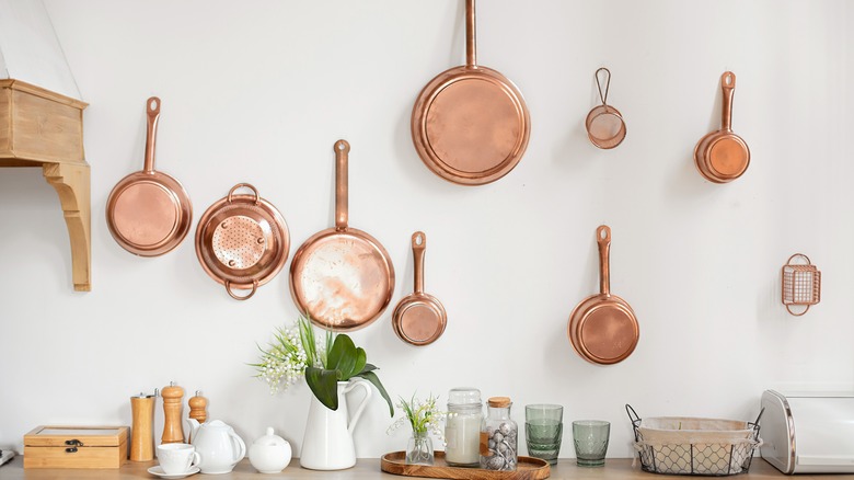 copper cookware hanging on kitchen wall