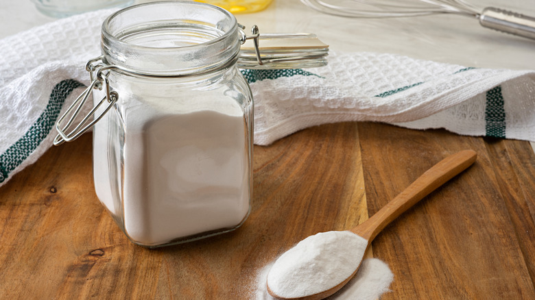 white powder in a glass jar and a wooden spoon