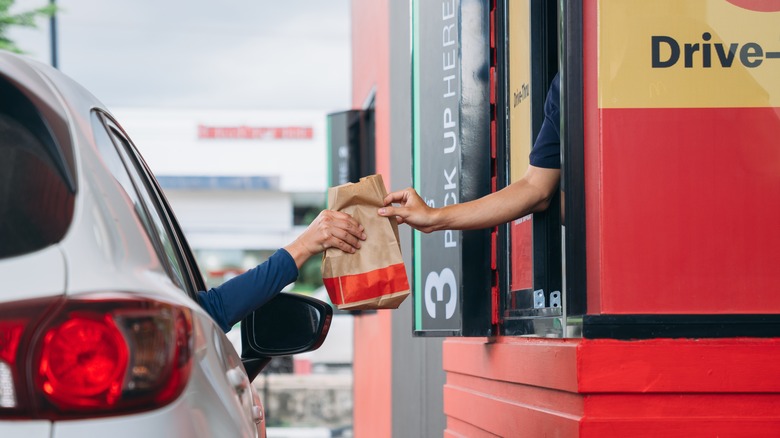 A car receiving a food order at a drive-thru