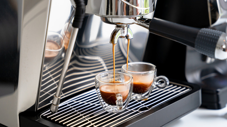 An espresso machine pouring out two espresso coffees