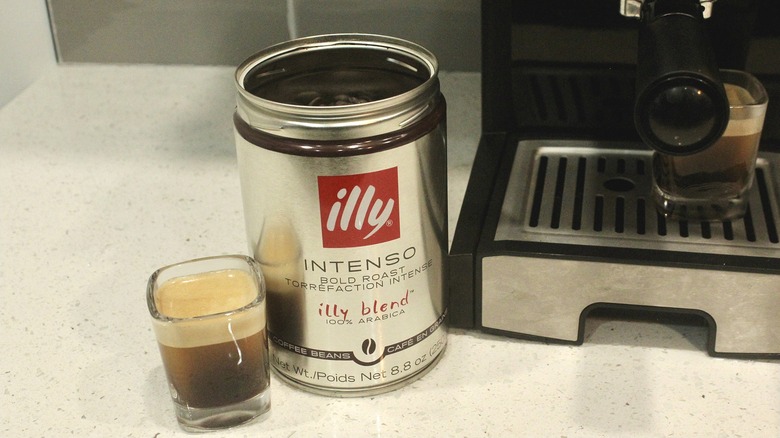 Can of illy coffee with espresso machine and shots