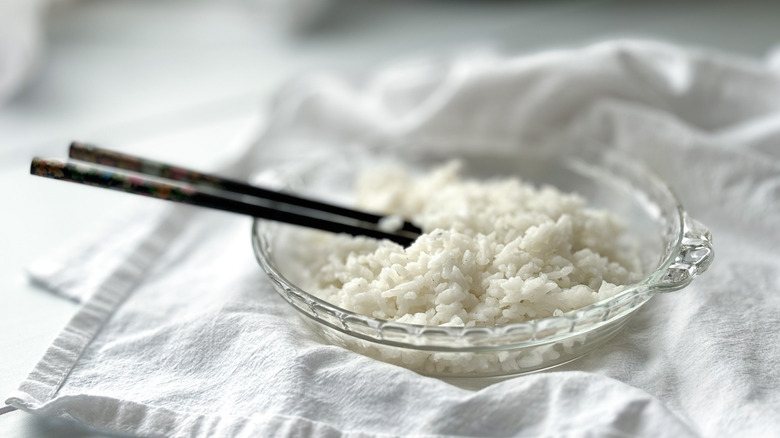 White rice in glass dish with black chopsticks