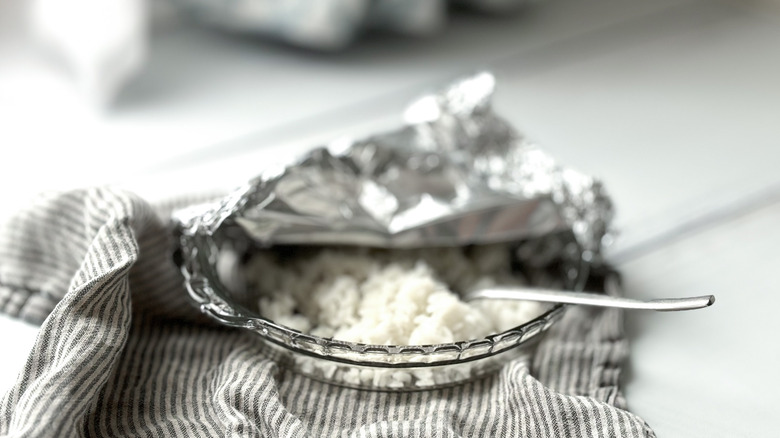 Glass dish of white rice with fork and foil