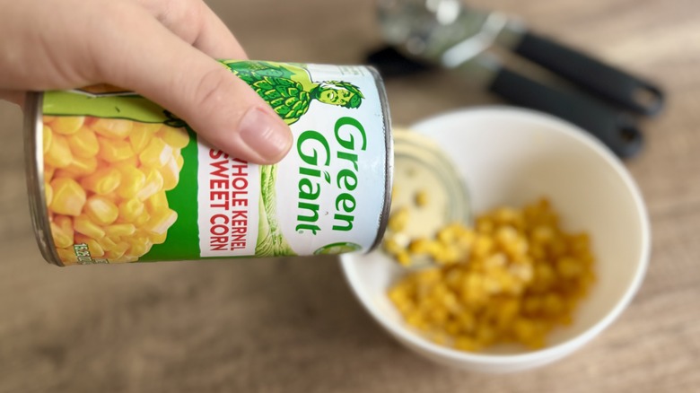 Pouring can of Green Giant corn