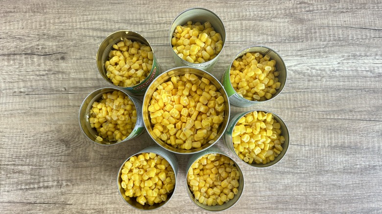 Eight open cans of corn