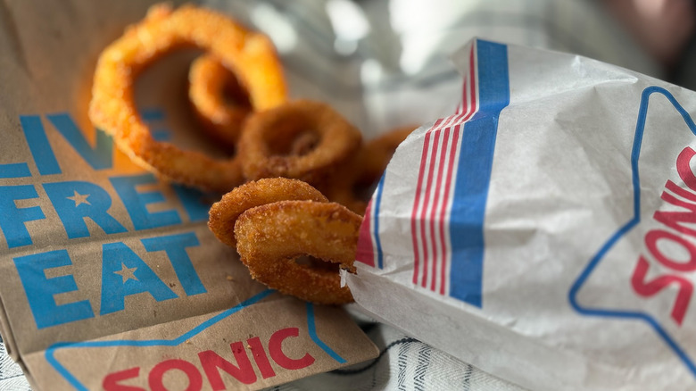 Sonic onion rings next to paper bag lit by sunlight