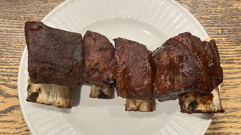 A set of four beef ribs come out of the oven