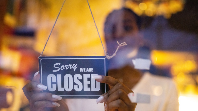 Employee putting closed sign in window