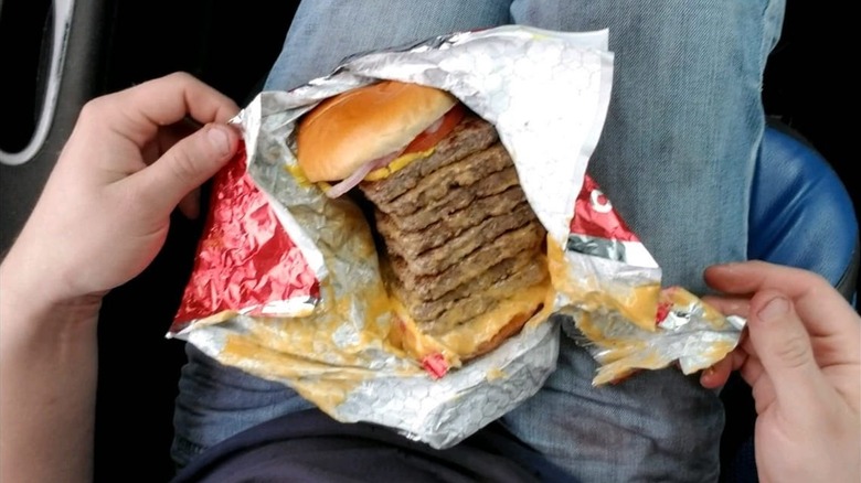 a T-Rex burger from Wendy's on someone's lap