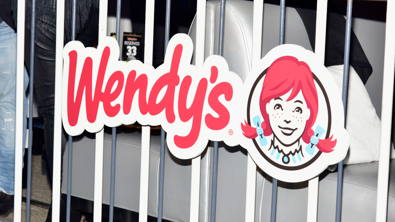 A Wendy's sign on dividing bars inside a venue.