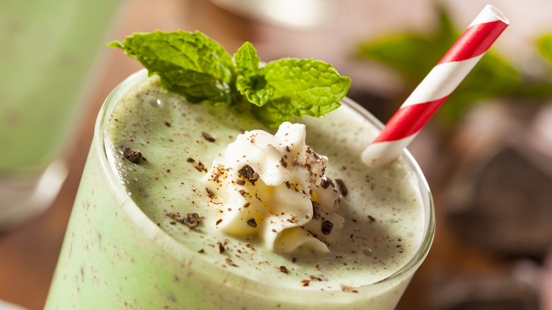 The top of a minty green shake is shown with a straw