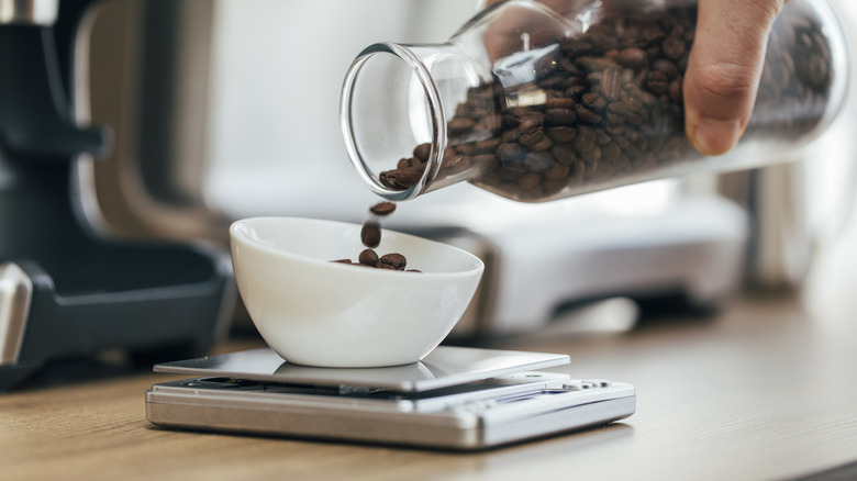 A barista weighing coffee beans on a scale