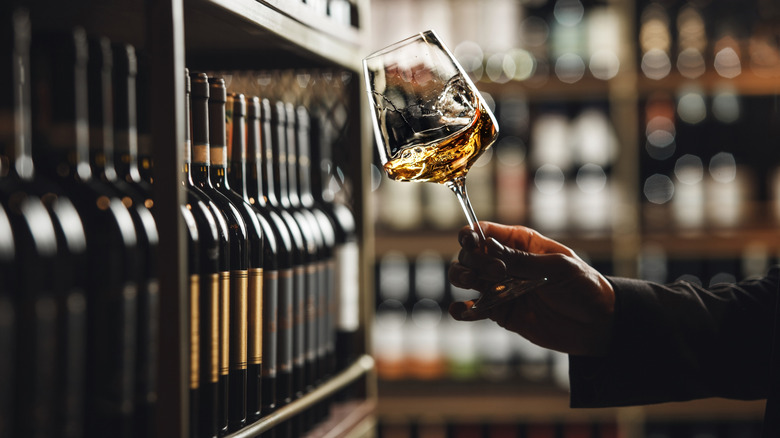 A person swirling white wine in a glass.