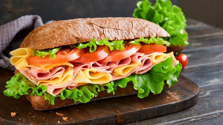 One huge submarine sandwich loaded with meat, cheese, and vegetables