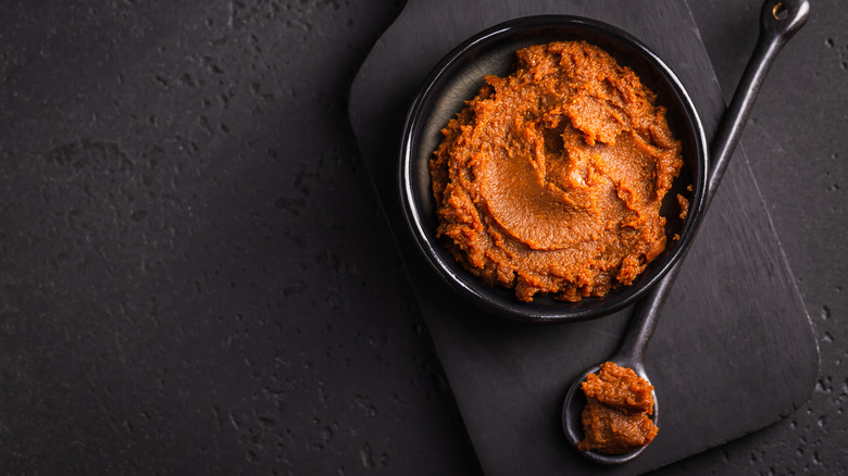 Miso paste in black bowl with black spoon