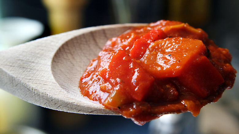 Close-up photo of chunky salsa on a wooden spoon