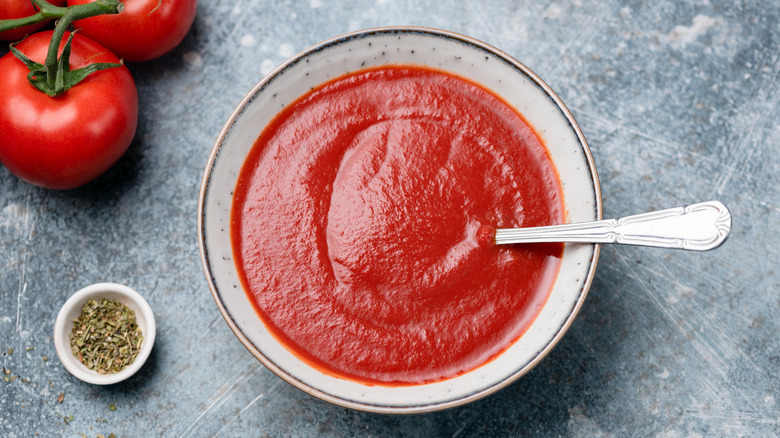 Tomato sauce in white bowl with spoon