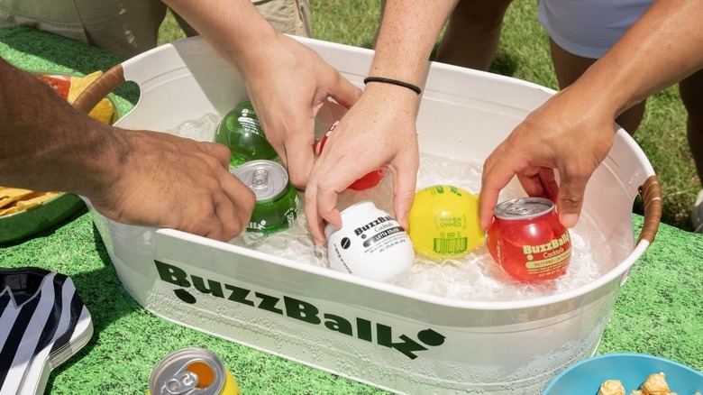 friends reach into BuzzBallz cooler full of different flavors at a party