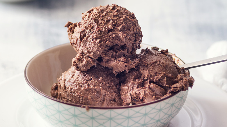 A bowl containing scoops of chocolate ice cream