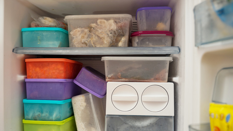 Multiple containers of food stuffed into a freezer