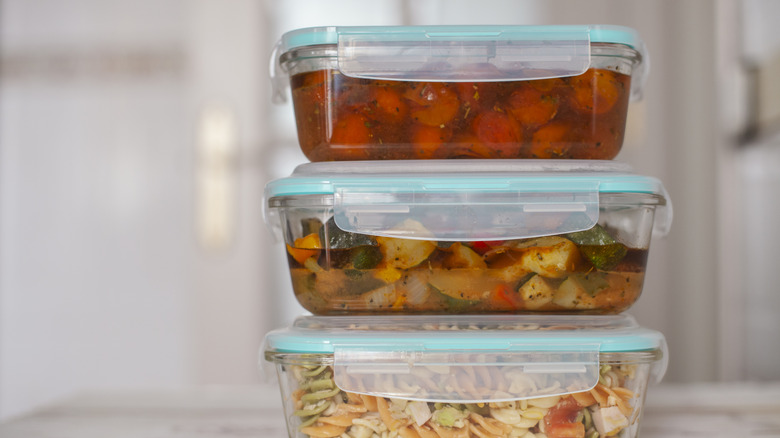 Three full glass food containers stacked on top of one another