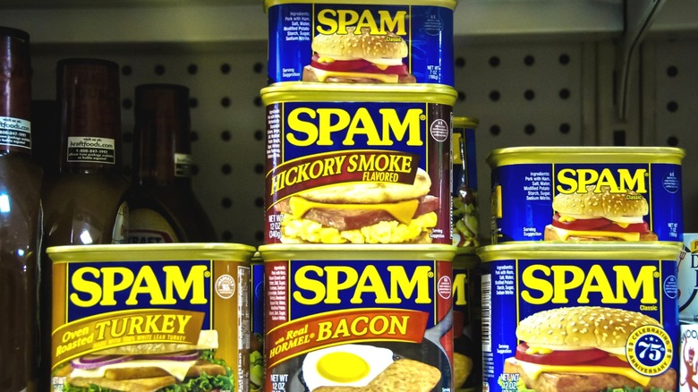 Several cans of Spam arranged on a supermarket shelf.