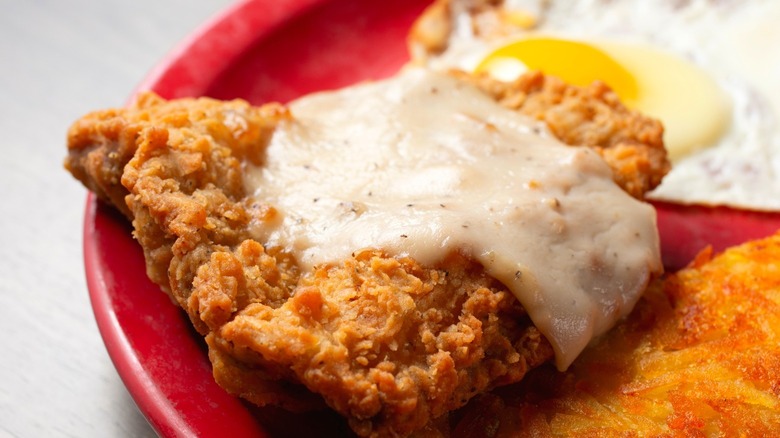 A close-up of chicken fried steak with white cream gravy