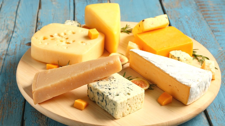 Several types of cheese arranged on a wooden board