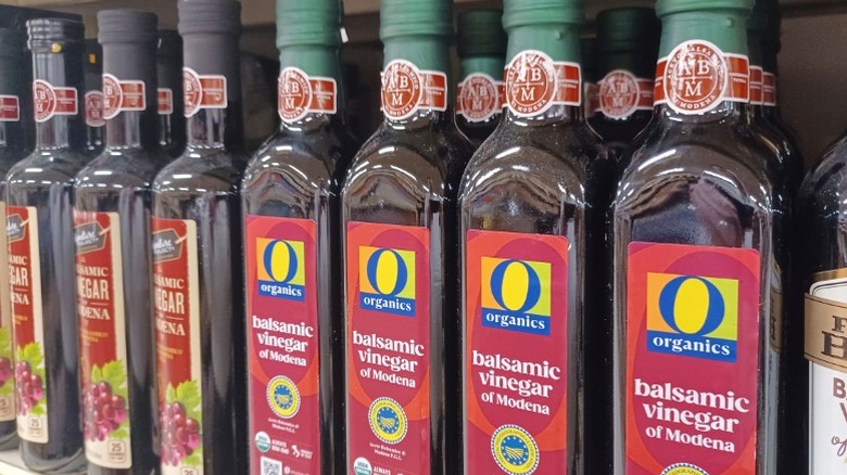 A row of balsamic vinegar bottles on a supermarket shelf