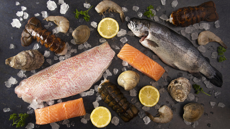 A variety of raw fish and shellfish displayed with ice and lemon