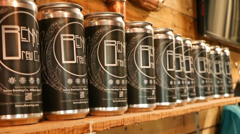 a line of crowlers of beer on a shelf