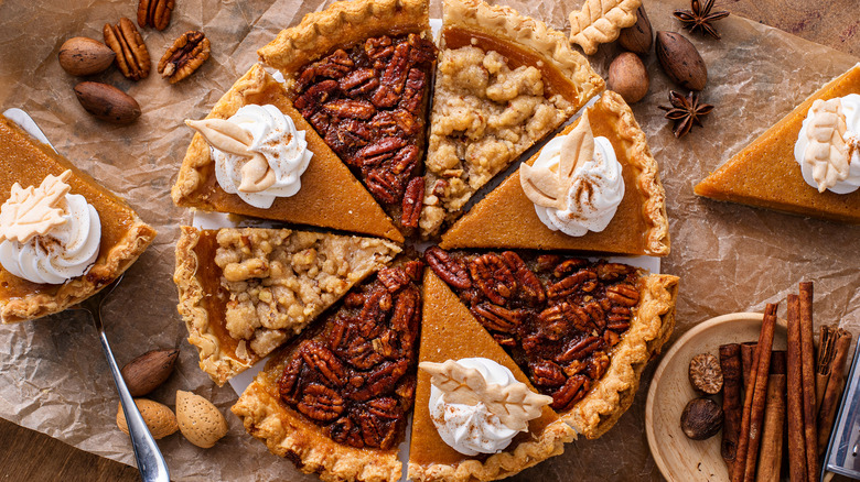 One whole pie made with slices of pumpkin, pecan, and apple crumble pies