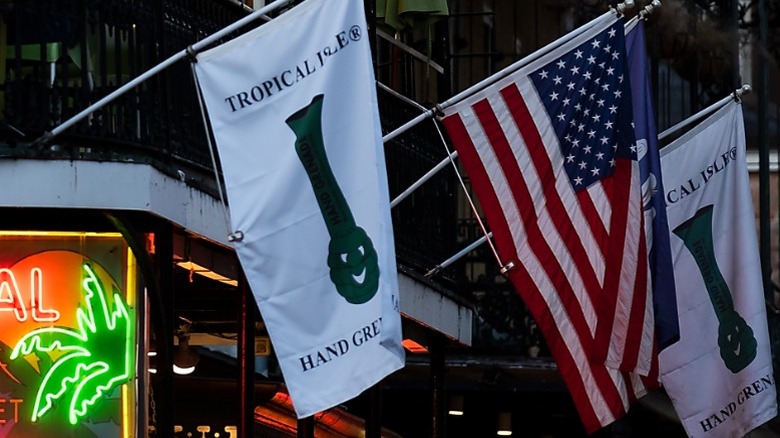 White flags with a green logo of the Hand Grenade drink