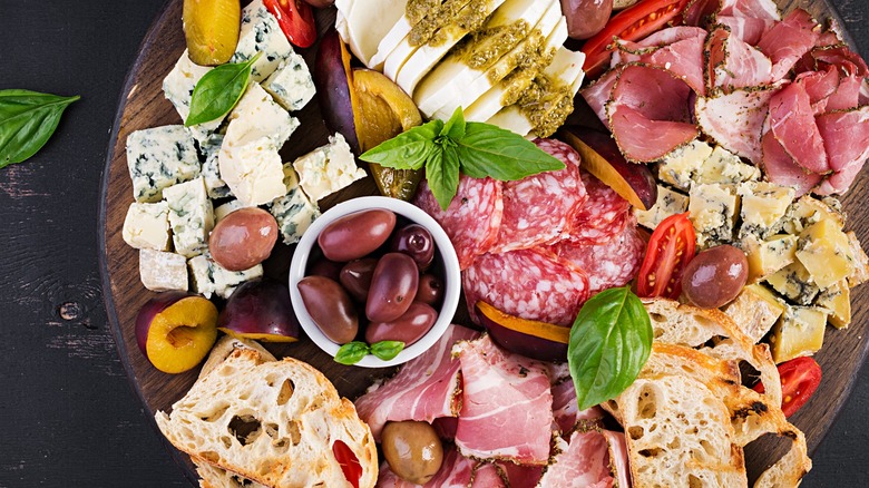 An antipasto platter filled with meat, cheese, and bread