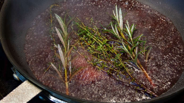 Pan deglazing with red wine, rosemary and thyme