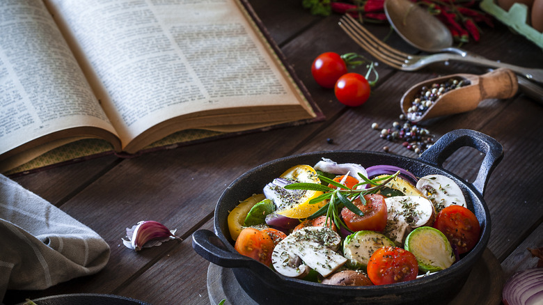 Cookbook surrounded by herbs and spices