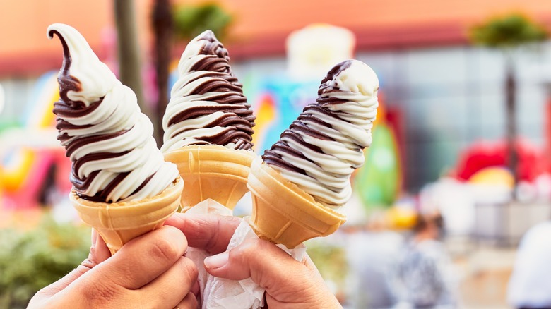 hands holding soft serve cones