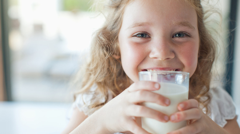 Close up of child smiling while drinking milk