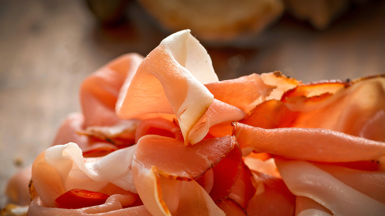 Cured ham slices on a wooden board