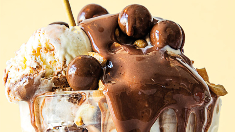 A tin roof ice cream sundae topped with chocolate sauce